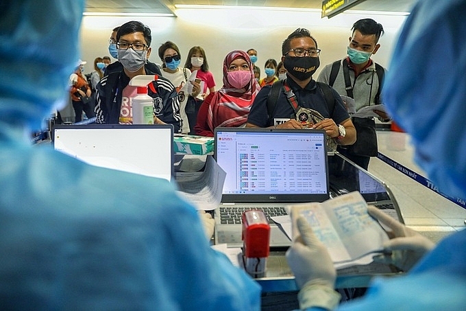 Foreigners carry out medical examinations at Tan Son Nhat airport before entering Vietnam on March 18. Photo: Huu Khoa.